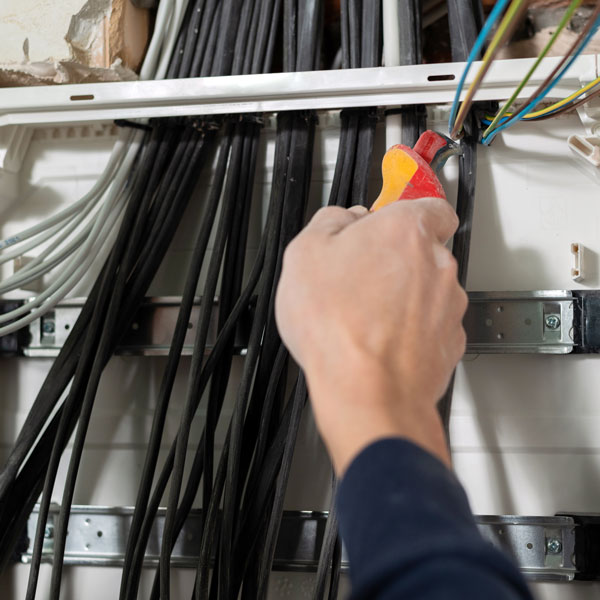 bunch of wires being pulled and fitted into panel